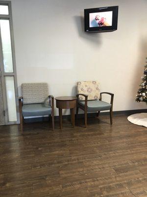 Same waiting room. Christmas tree in corner