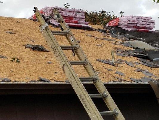 Old shingles being removed down to the decking