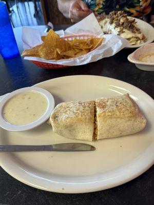 California burrito with white queso and big burrito on the back with added beef and chicken