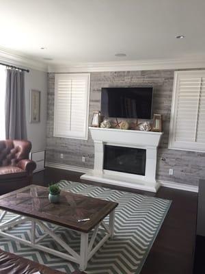 Dark flooring looks great when there is contrast with walls and rugs.  Note the new wood planking on the fireplace wall.  Great idea!