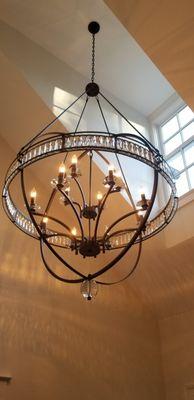 Installation of a chandelier in a high ceiling.