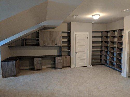 Custom home office in grey wood grain and oil-rubbed bronze. Built-in desk, wall mounted storage cabinets and adjustable shelves.