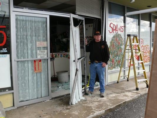 Ed is holding the remainder of what used to be a storefront door after a car crashed through the entryway!