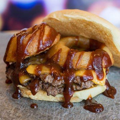 A two-patty Texan delight. Topped with cheddar cheese, our signature crispy onion rings, and a BBQ sauce