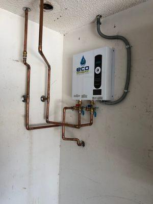 Tankless electric water heater installed on the garage wall.