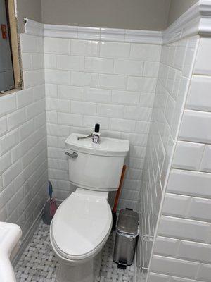 Beveled subway tiles, crown on top, and ceramic baseboards on the bottom. Gray lady Basketweave  floor