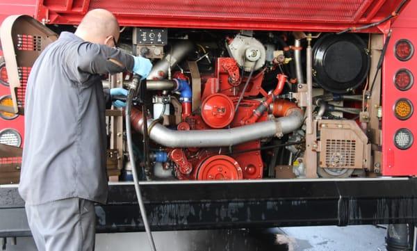 A transit bus engine being cleaned before service