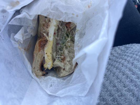 Plain sausage breakfast bagel with extra hot sauce,sprouts and cucumber