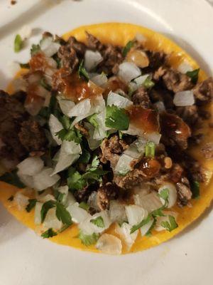 Carne asada taco with onions cilantro and red salsa