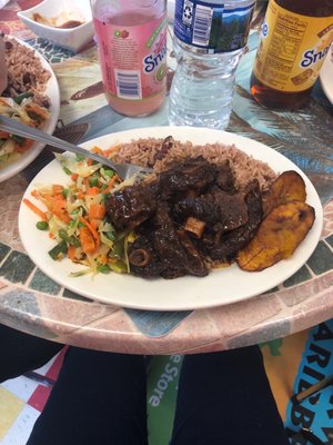 Oxtail with peas and rice, cabbage and plantains