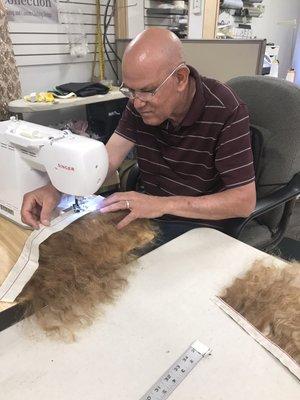 Gregory sewing the wefts together for the little girl so I can install it after almost a year when I had to shave it