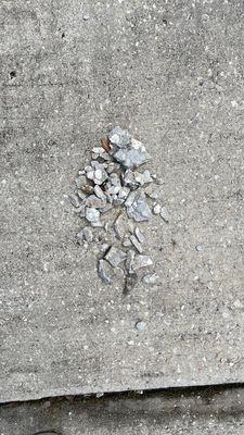 Fragments left from the gouges and new cracks on my driveway, caused by the placement of Sheegog's waste dumpster.