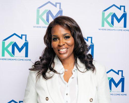 Tammy Jackson - Managing Broker - Standing Infront of the billboard of KM Realty Group LLC