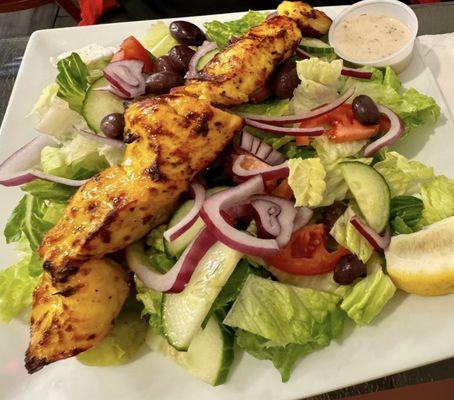 Over salad. 
Choice of meats: Khoobideh skewers,Joojeh Kabobs,Kofta, veggie Kofta,