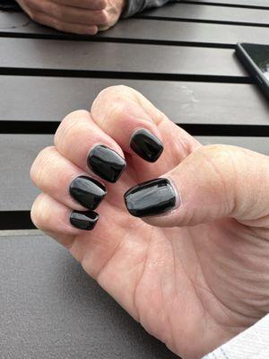 Hand with black gel nails.