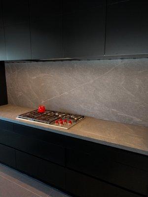 Beautiful natural stone counters, and matching full height slab backsplash.