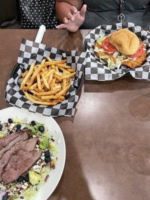 Pork chop sandwich with a side of fries and Blueberry Steak salad.