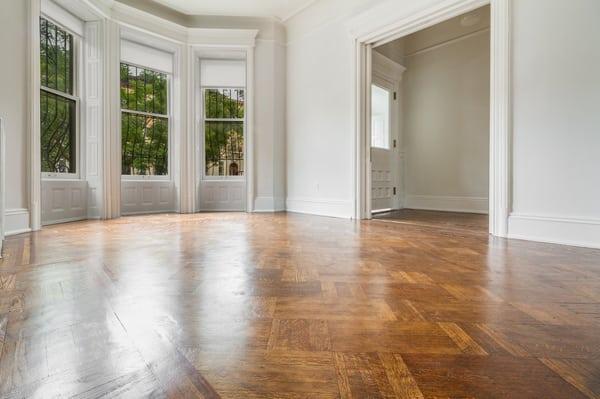 Oversized windows let light shine off of original parquet flooring