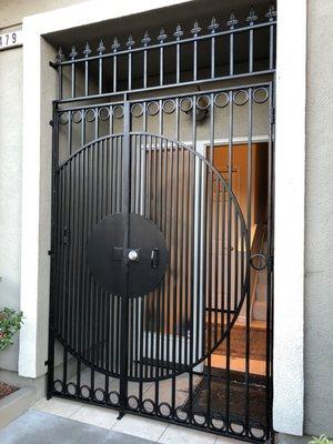 Gate with topper, close set bars & round security plate around lock.