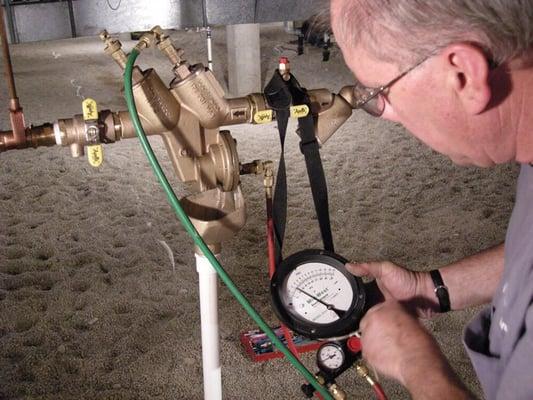 A technician testing a backflow prevention device