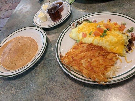 Meat lovers omelette with hash browns and pancakes