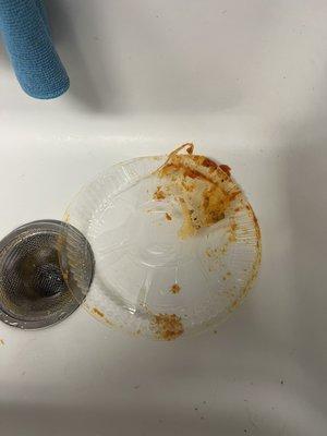 Pictures of what is supposed to be meat lasagna and a melted plastic lid due to poor delivery handling.