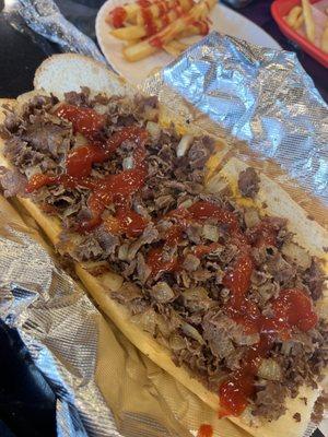 Cheesesteak with fried onions, cheese wiz and ketchup