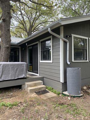 Half-round galvalume gutters with round downspouts and rain barrel