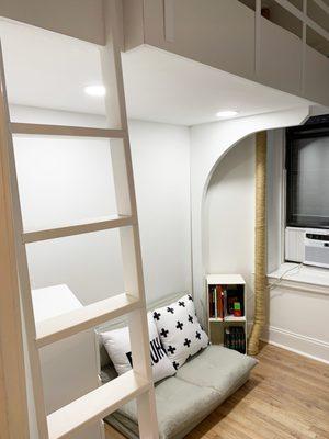 Loft with arched support, sheetrock "ceiling," and recessed lighting.