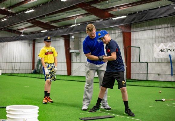 Korey teaching the proper movements of a swing and emphasizing the hip/shoulder separation throughout the motion.