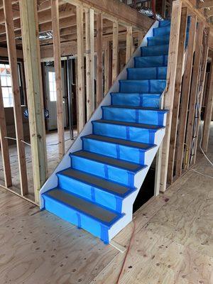 Brand new stairs with red oak treads, primed stringers and risers. With installation of stair protection.