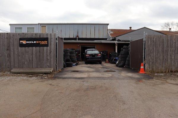 Back entrance of tire shop where you drive up to receive service, located on Atlantic Ave.