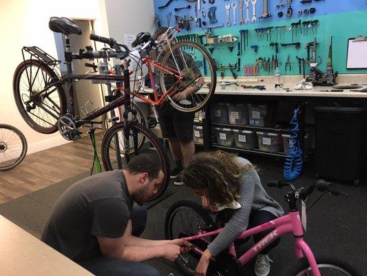 Adding trainer wheels to a child's new bike.