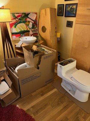 left from just-finished bathroom reno - one old toilet, one new one with a big crack through, a wooden vanity in two parts with a basin.