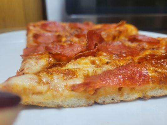 Side view: Zero pizza sauce. No cheese pull. No flavor. Overcooked and dry as cardboard.