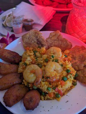 Shrimp with yellow vegetable rice with tostones and sweet plantains.