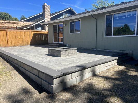 Raised patio, retaining wall, and fire pit.