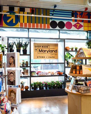 Window full of plants and other merchandise as well as a view of our mural at the top.