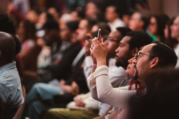 Person taking a photo during a sermon.