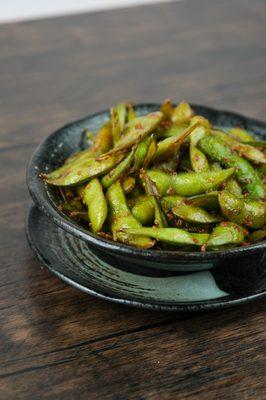 Unleash your taste buds with our Spicy Garlic Edamame!  A fiery twist on a classic favorite.