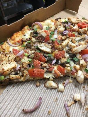 Doordash pizza with tomatoes, scallions, onion, chicken, and a cheese base