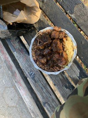 A couple pieces of oxtail lot of rice, cabbage, fried plantain