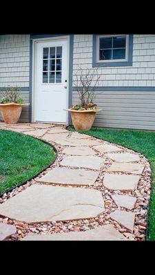 Limestone pavers set in pea gravel with metal edging