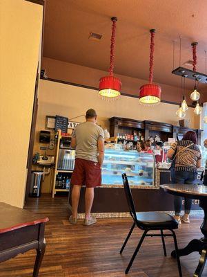 Counter with many treats including croissants and quiche.