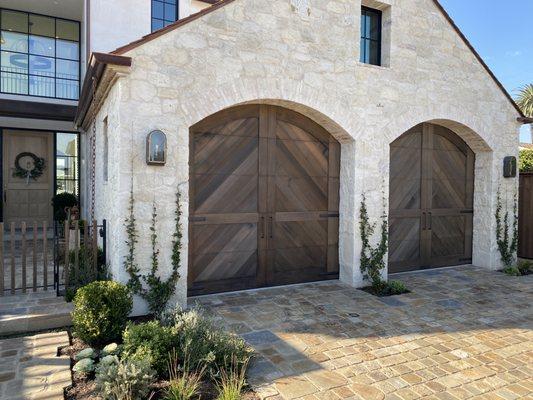 Custom made clear vertical grain cedar garage doors with herringbone pattern and arched tops were the perfect fit for this Costa Mesa Home.