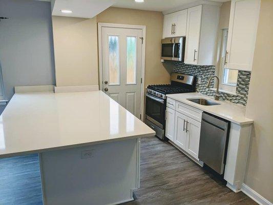 New cabinets, quartz counters, glass tile backsplash, lighting & plumbing fixtures, LVP flooring, and appliances