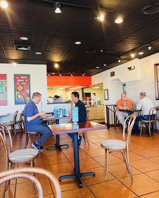 Seating area, kitchen, bathroom past the guy in the orange shirt