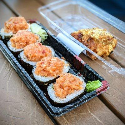 Spicy salmon sushi roll and piece of chicken