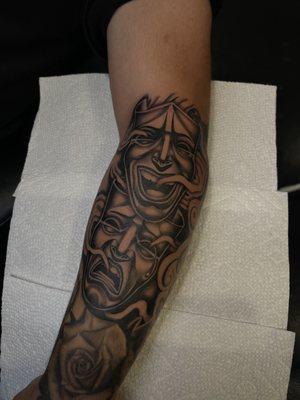 Laugh now, cry later. Black and gray chicano style arm tattoo by Richard at Iron Will Tattoo, top shop in San Antonio.