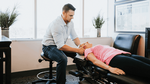 Dr. Robert Rogers performing an adjustment on a young professional.